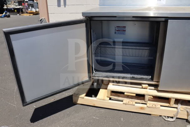 True TWT-60F-HC worktop freezer with open door, stainless steel, 60 3/8" width, 3 9/16" backsplash, on a pallet.