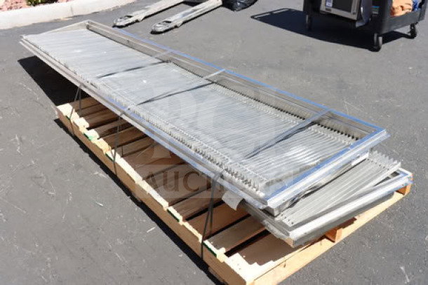 Two Regency 600FT1260SS 12"x60" stainless steel floor troughs with grates, brand new scratch-n-dent condition, on a pallet.