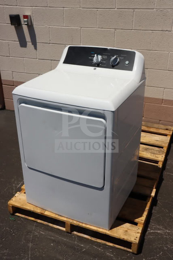 Brand new GE GTX52EASPWB 6.2 cu. ft. electric dryer on a pallet, front load, visible knobs, possible dents and scratches.
