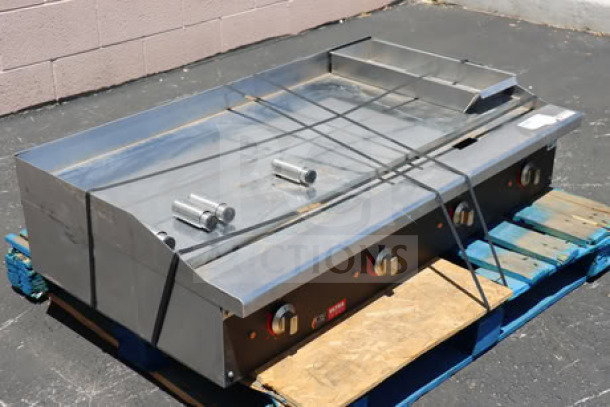 Cooking Performance Group GU-CPG-48-M 48" chrome electric countertop griddle, visible scratches and dents, on a pallet.