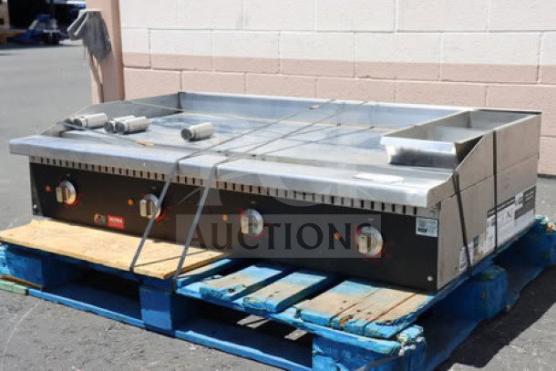 Cooking Performance Group GU-CPG-48-M 48" chrome electric griddle, scratched and dented, on blue pallets, visible model label.