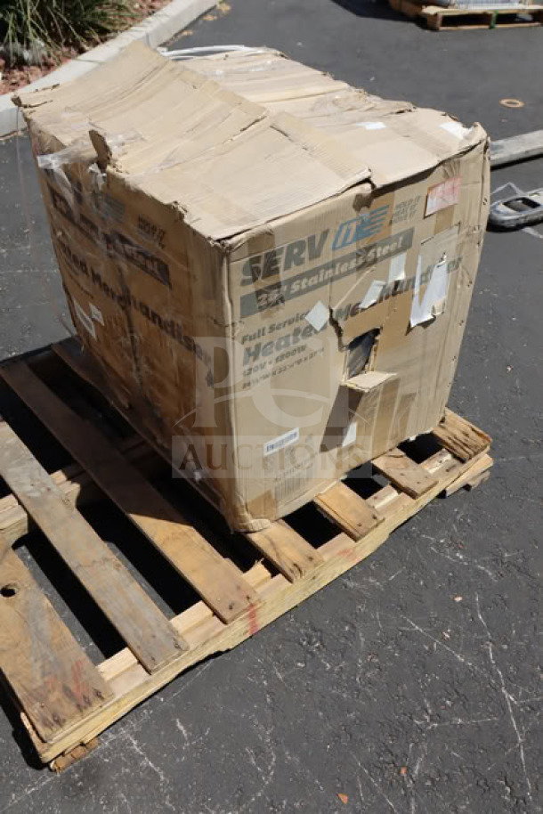 Damaged box of ServIt HDM-26 countertop heated display case on pallet, packaging scratched and dented.