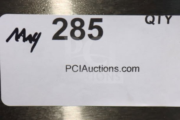 Sticker on a metallic surface with "285", "QTY" handwritten, and "PCIAuctions.com" printed.