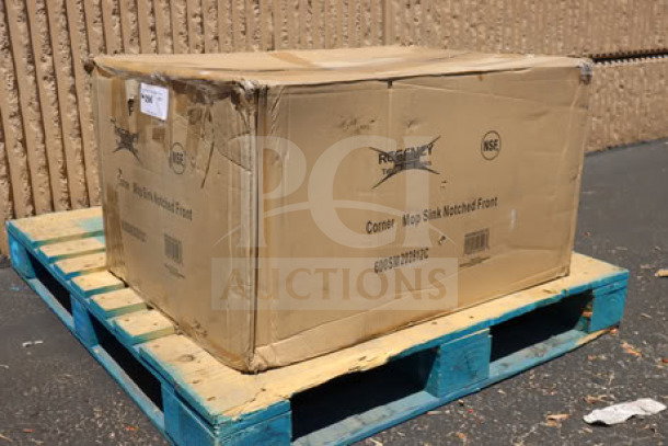 Regency mop sink boxed on pallet, 600SM202812C model. Packaging shows minor wear. Marked “Corner Mop Sink Notched Front.”