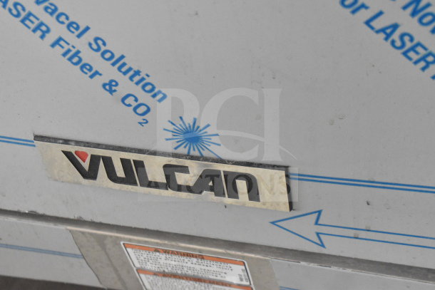 Vulcan 72SS-6B36GTN gas range close-up, showing logo plate. Features six burners, griddle, two ovens, backsplash.