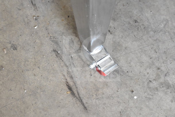 Migali convection oven metal leg with attached commercial caster on concrete surface.