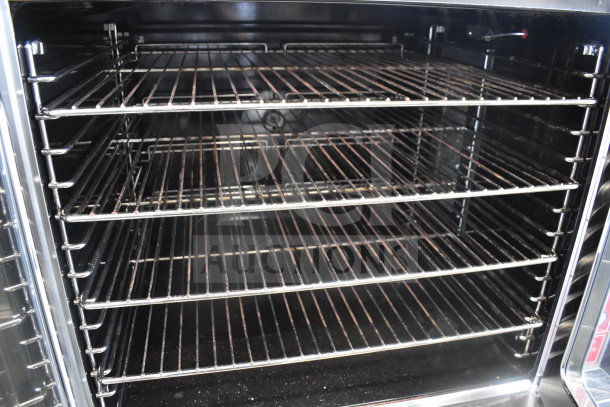 Migali commercial gas convection oven, view-through doors, metal legs on casters, five adjustable racks, excellent condition.