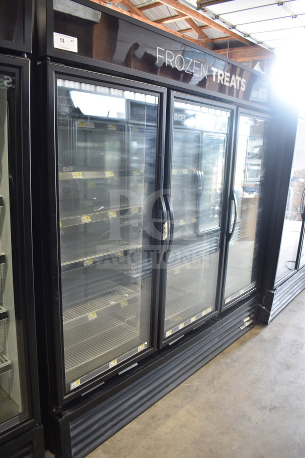 2017 True GDM-72F-HC three-door reach-in freezer merchandiser, 115/208-230V, 1 phase, tested and working, shown in a storefront.