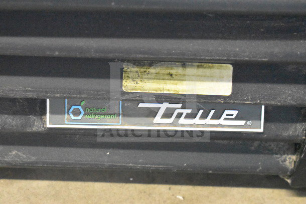 2019 True GDM-72-HC cooler label; features natural refrigerant. Model's logo visible on a black surface.