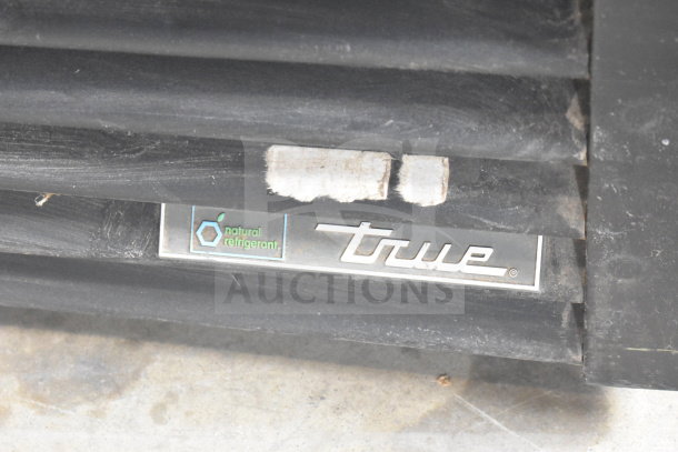 True GDM-72F-HC Commercial Freezer badge showing "natural refrigerant" branding, black surface, visible wear.