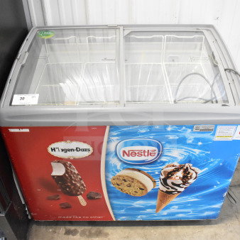 AHT RIO S 100 commercial chest freezer merchandiser with glass lid, featuring Haagen-Dazs and Nestle branding. 115 Volts, good condition.