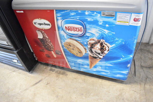 AHT RIO S 100 commercial chest freezer with vibrant ice cream graphics, 115 volts, 1 phase. Visible Nestlé and Haagen-Dazs logos.