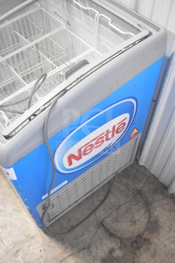 AHT RIO S 100 Commercial Chest Freezer with Nestlé branding. 115 Volts, 1 Phase. Features wire baskets and power cord.