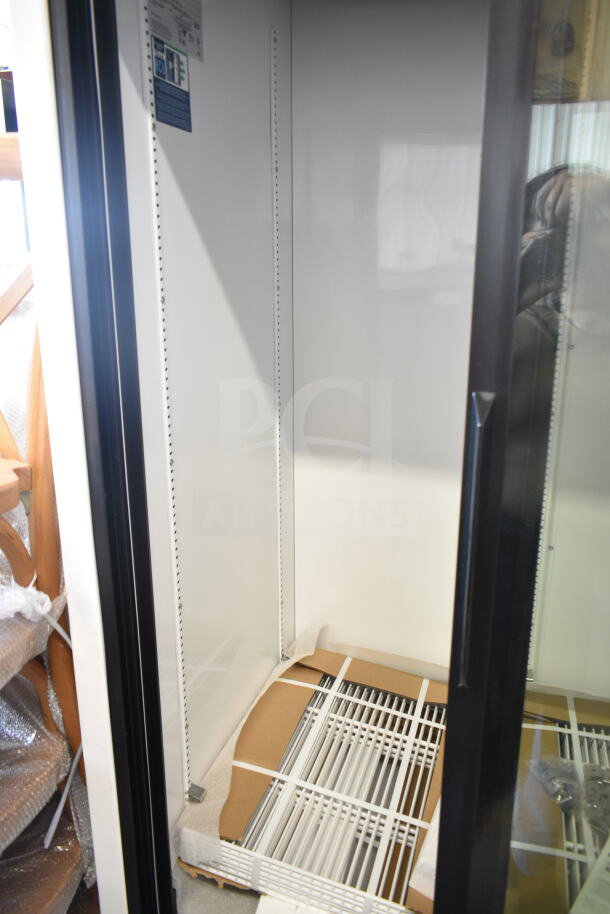 Brand new True GDM-33-HC-LD commercial cooler, 2-door, 115 volts, visible interior features, minor scratches, dented exterior.