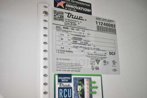 Label of True GDM-33-HC-LD cooler showing model details, compressor specs, refrigerant type, and safety warnings.