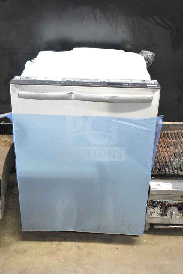 Frigidaire undercounter dishwasher, stainless steel finish, protective wrap, visible controls, excellent condition.