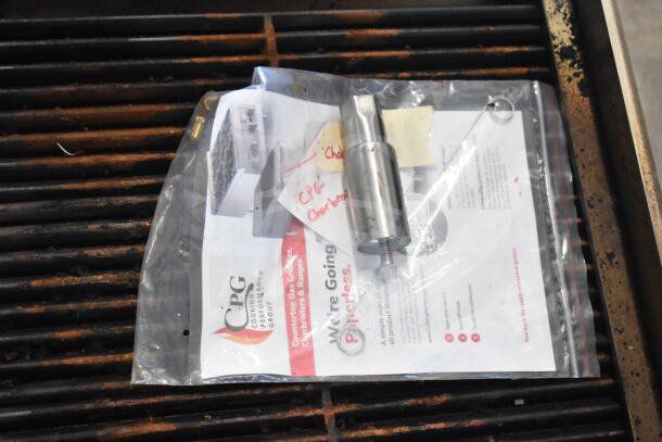2025 Cooking Performance Group CR-CPG-36-NL 36" charbroiler on grill, with accessory and manual in plastic bag on top.
