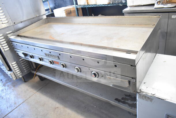 Vulcan commercial gas-powered flat top griddle with under shelf. Features control knobs, visible wear, and Vulcan branding.