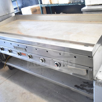 Vulcan commercial gas-powered flat top griddle with under shelf. Features control knobs, visible wear, and Vulcan branding.