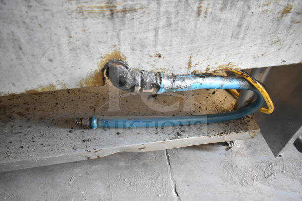 Vulcan commercial gas griddle underside, showing connections and shelf. Visible rust and wear indicate used condition.