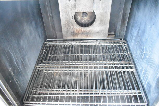Imperial commercial full-size convection oven interior with metal racks and fan, showcasing durable construction and capacity.