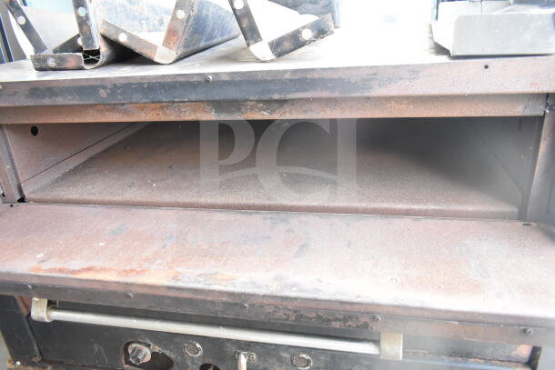 Vulcan commercial natural gas 2-deck pizza oven with metal legs, visible wear and rust, sturdy construction.