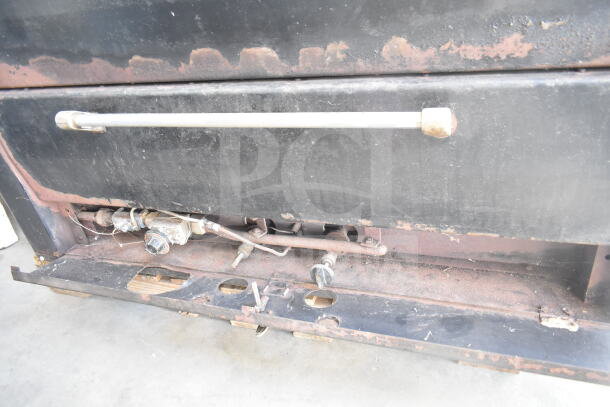 Vulcan commercial 2-deck pizza oven with metal legs, natural gas powered, visible wear and rust, sturdy handle, industrial controls.