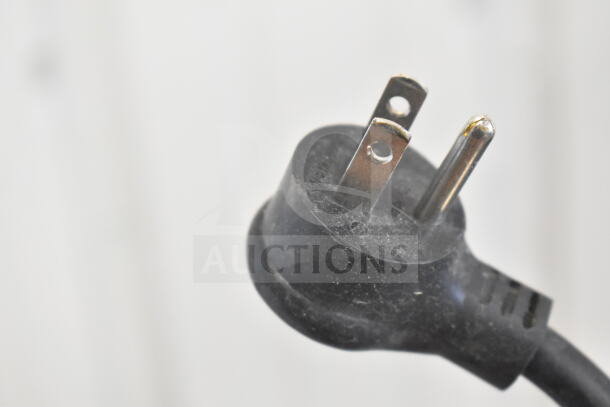 Close-up image of a black grounded power plug for the 2018 True GDM-06-34-HC cooler, showing slight dust.