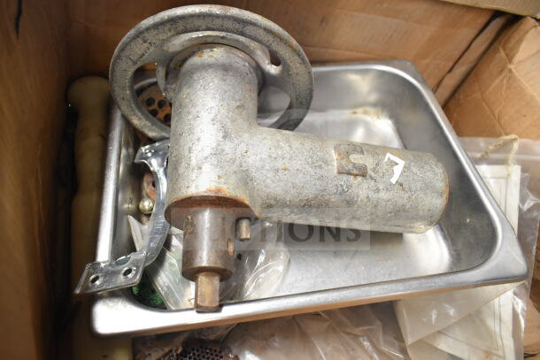Meat grinder attachment with tray, metal construction, slightly rusted, includes additional components, suitable for kitchen use.