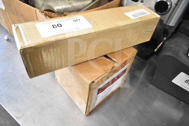 Two cardboard boxes with auction labels, showing item 80 and packaging details, on a metal surface.