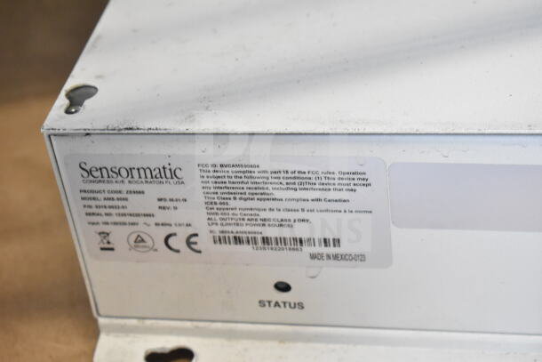 Sensormatic ZE9060 controller with label, model AMS-9060, made in Mexico. Visible ports and status light. Signs of wear.