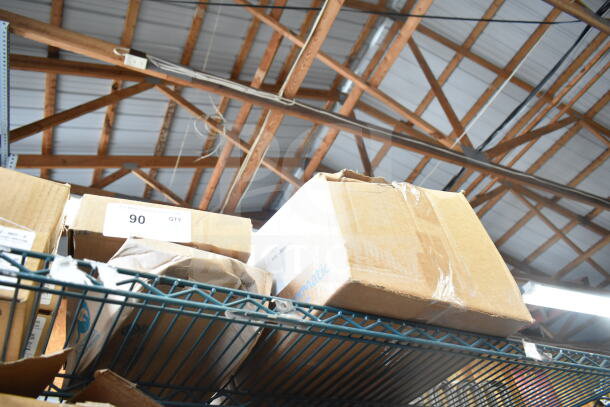 Boxes containing Sensormatic Remote Alarm Module Kit, Deactivator Antenna, ZBSMP-B2 Mount on metal shelf.