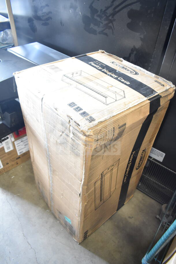 Cardboard box of KoolMore KM-DC-3CSBK 33" 2-tier pastry display case with shelf and sliding door, 3.2 cu. ft. capacity.