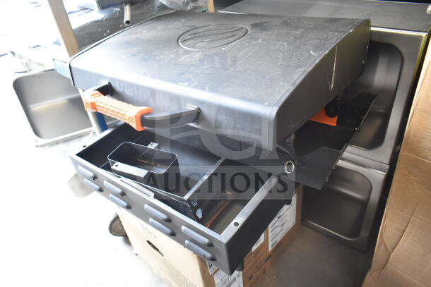 Flat top griddle for grill with durable black finish, orange handle, and grease tray. Appears in good condition.