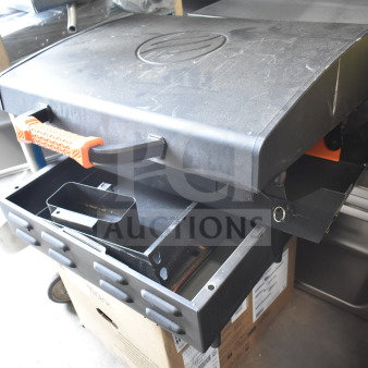 Flat top griddle for grill with durable black finish, orange handle, and grease tray. Appears in good condition.