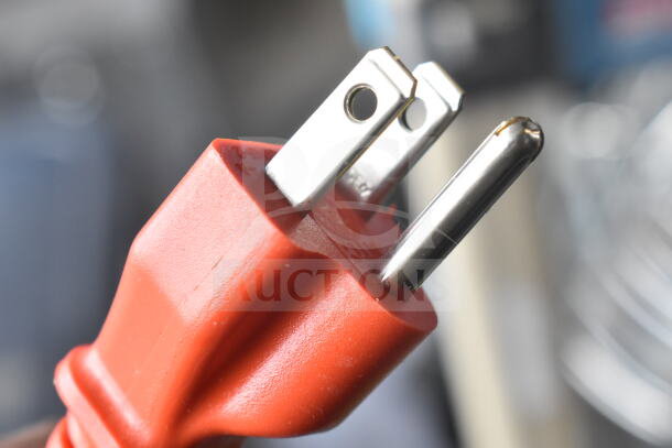 Close-up image of a red power plug for a KitchenAid KSMC895CU mixer, showcasing metal prongs.