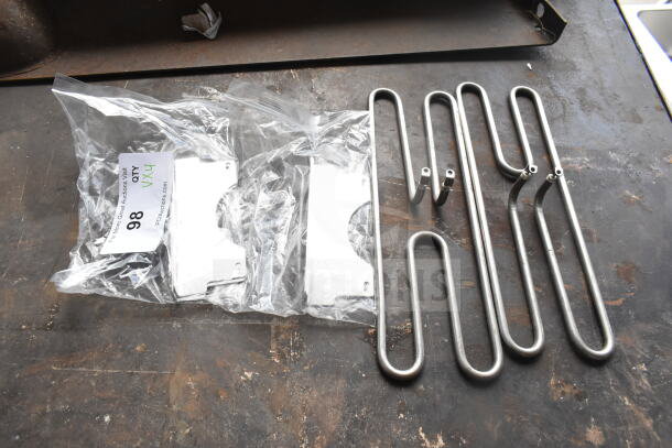 Four brand new scratch and dent items, including two metal burners and metal pieces, labeled "qty 4x4," auction lot 98.