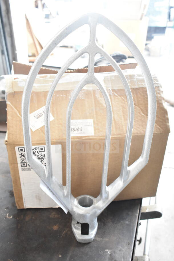 Brand new Vollrath 40776 flat beater for 40759 40 Qt. mixer. Slight scratches and dents visible. Box with shipping labels in the background.