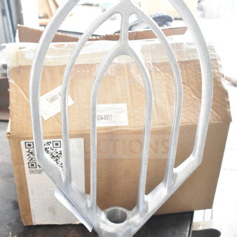 Brand new Vollrath 40776 flat beater for 40759 40 Qt. mixer. Slight scratches and dents visible. Box with shipping labels in the background.