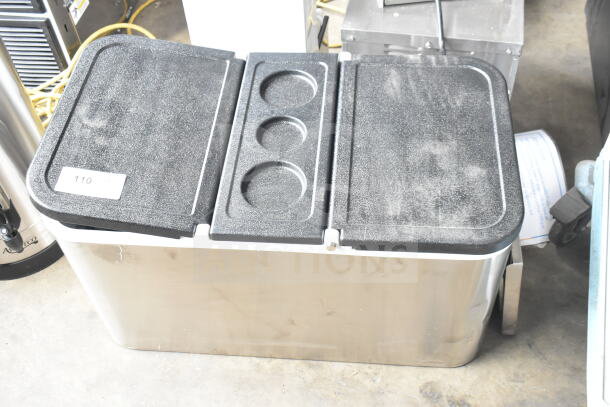 Brand new cooler with scratch and dent marks, features sturdy black lid with cup holders, labeled "110."