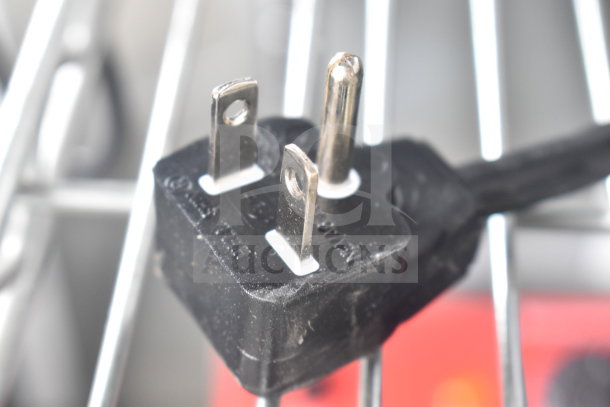 Close-up image of a power plug for a Solwave SWAHD18 microwave, showing prongs and text markings on the plug.