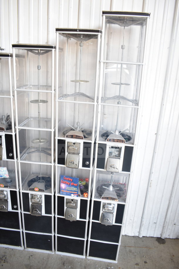 Five double stack vending machines with clear compartments, metallic coin slots, black panels. Some contain dice and candy promotions.