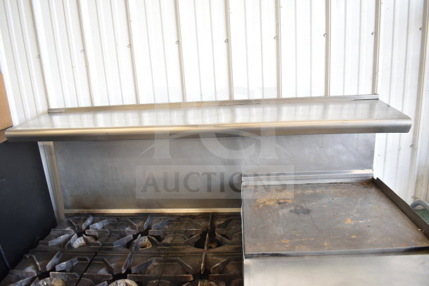 American Range commercial gas 6-burner range with flat top griddle, two ovens, overshelf, backsplash, on commercial casters.