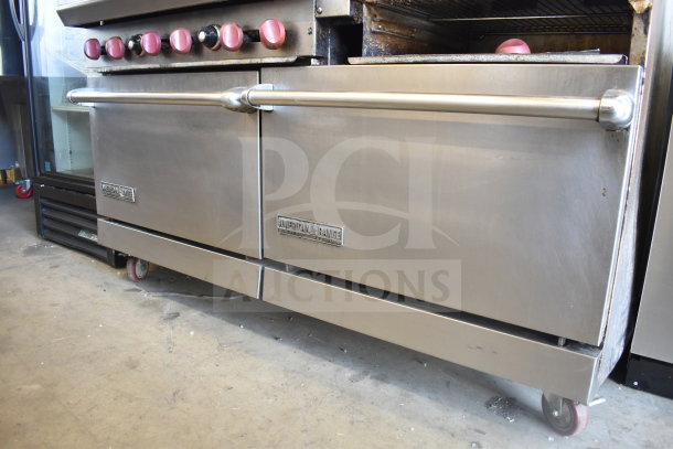 American Range commercial gas range with 6 burners, flat top griddle, 2 ovens, overshelf, backsplash, on casters.