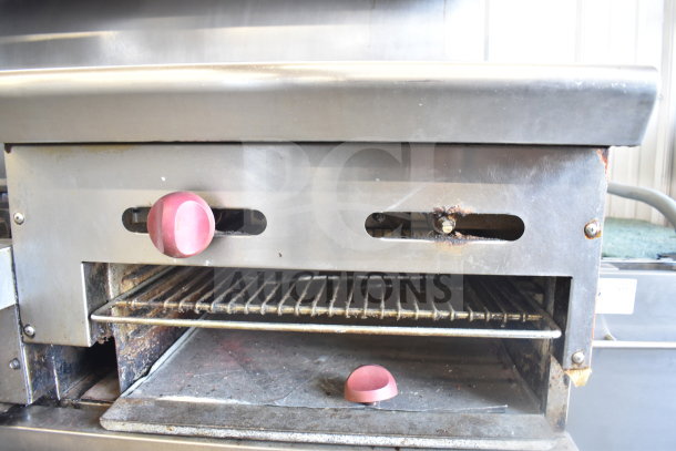 American Range commercial gas stove, 6 burners, flat-top griddle, 2 ovens. Features overshelf, backsplash, on casters. Used condition.