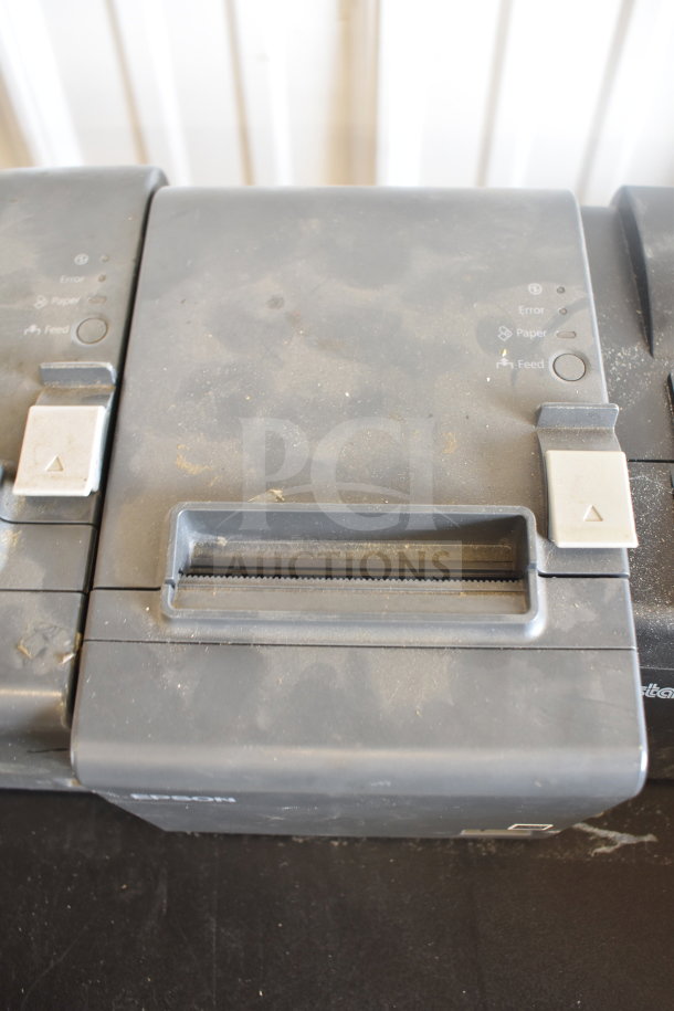 Five receipt printers, including Epson and Star TSP100III models, in used condition with visible surface dust.