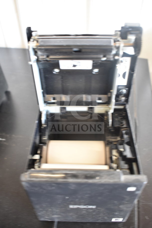Five receipt printers including Epson and Star TSP100III, in used condition. Visible wear on surfaces.