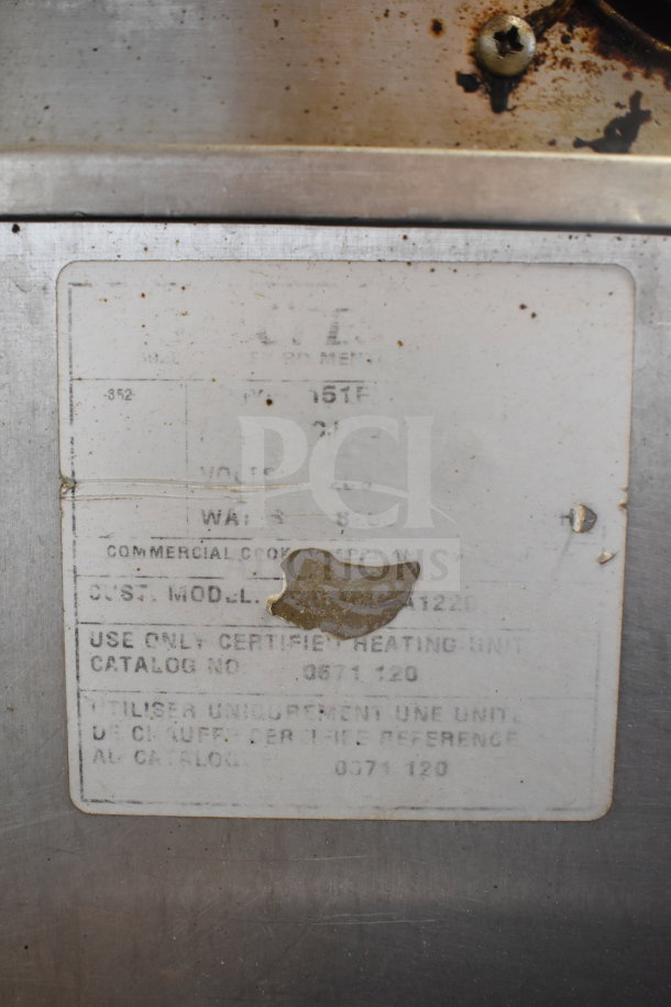 CreCor Commercial Heated Holding Cabinet label shows equipment details and specifications. Visible wear on the metal surface.