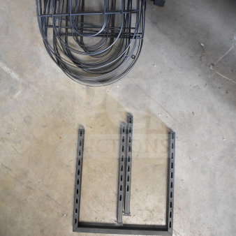 Lot of various metal racks, black finish, includes multiple curved and vertical pieces, suitable for storage solutions.