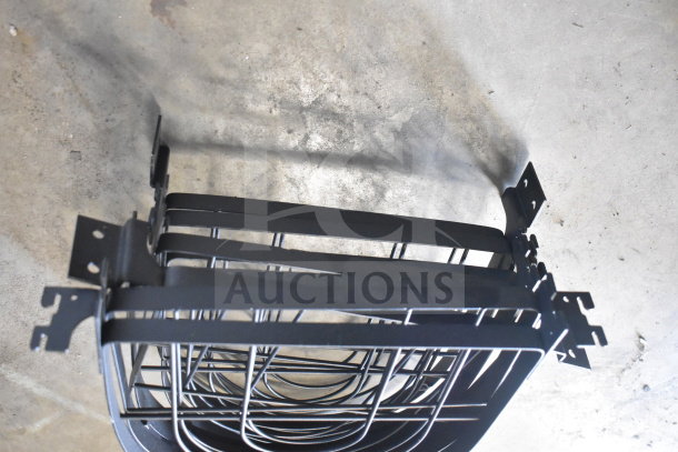 Lot of various black metal racks with brackets, in good condition, stacked on a concrete floor.